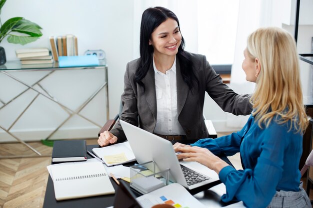 Mujeres sonrientes de tiro medio trabajando juntas