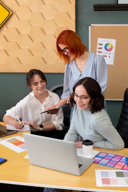 Mujeres sonrientes de tiro medio en el trabajo