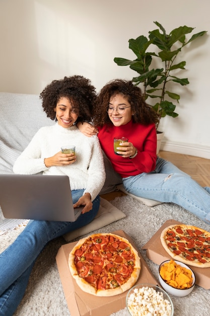 Mujeres sonrientes de tiro medio viendo películas