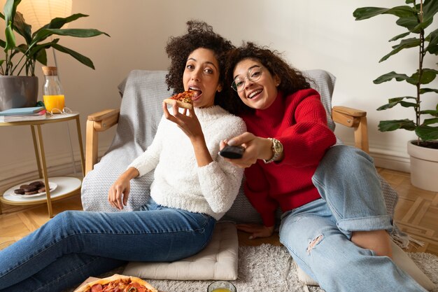 Mujeres sonrientes de tiro medio viendo películas