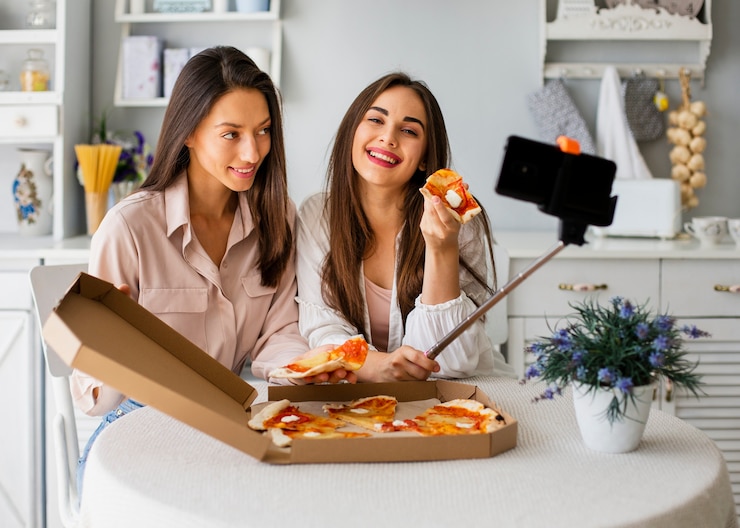 Foto gratuito mujeres sonrientes tomando selfie mientras comen