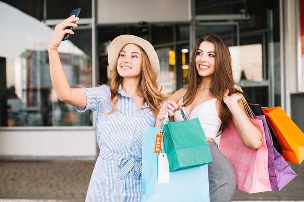 Mujeres sonrientes tomando selfies