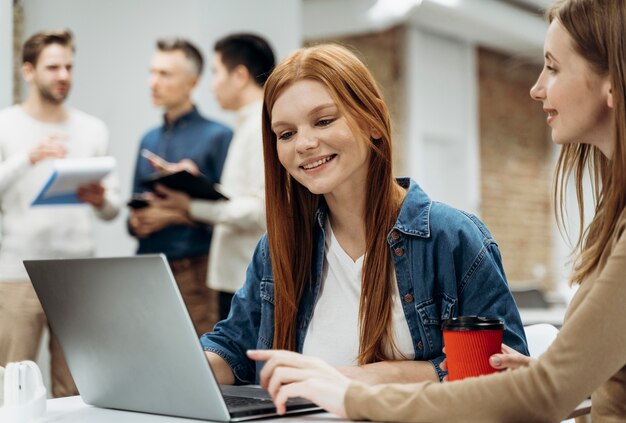 Mujeres sonrientes trabajando juntas en un proyecto