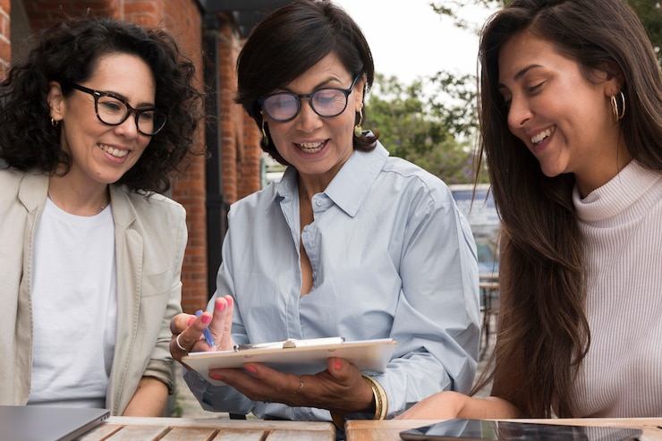 Foto gratuito mujeres sonrientes trabajando juntos al aire libre