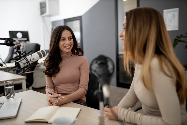 Mujeres sonrientes transmitiendo en radio juntos