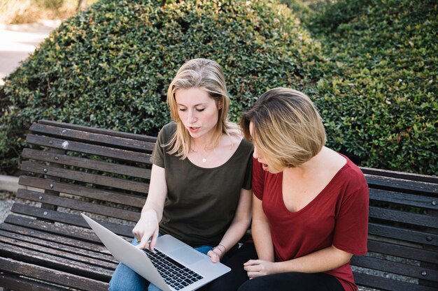 Mujeres sorprendidas apuntando a la pantalla de la computadora portátil