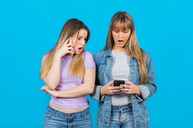 Foto gratuita mujeres sorprendidas por el contenido del teléfono