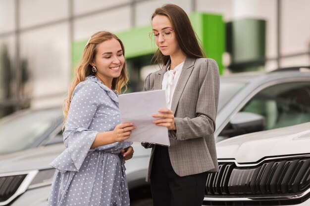 Mujeres sosteniendo un contrato y mirándolo