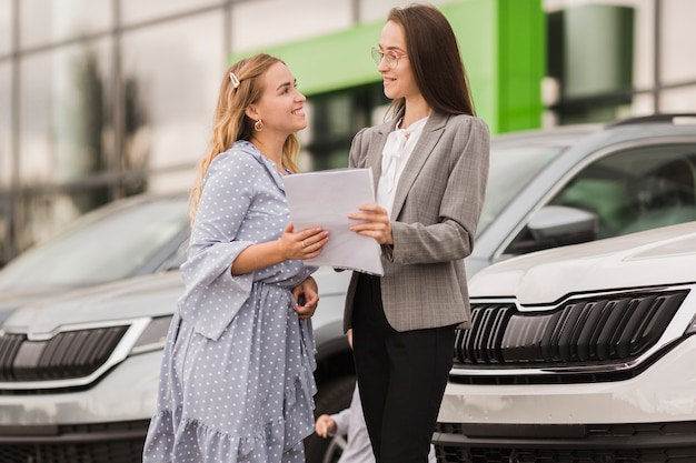 Mujeres sosteniendo un contrato y mirándose