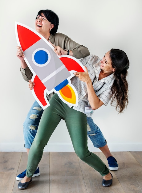 Foto gratuita mujeres sosteniendo el icono de cohete