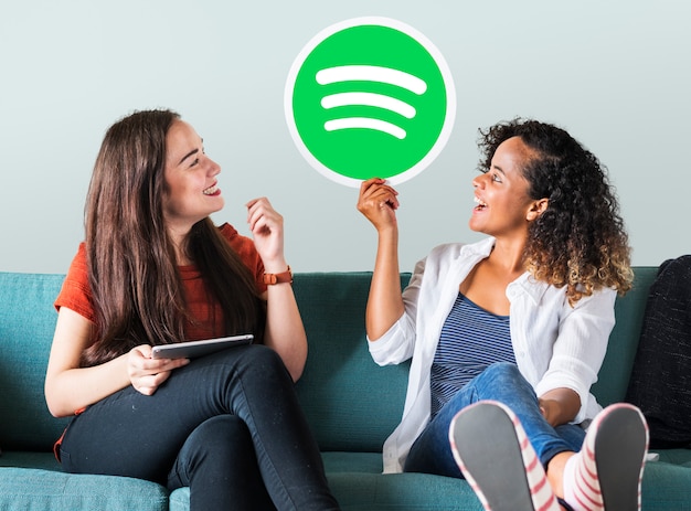 Foto gratuita mujeres sosteniendo un icono de spotify