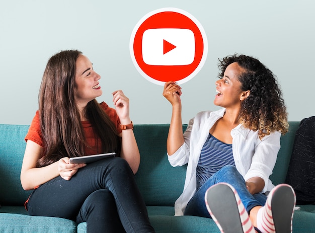 Mujeres sosteniendo un icono de YouTube