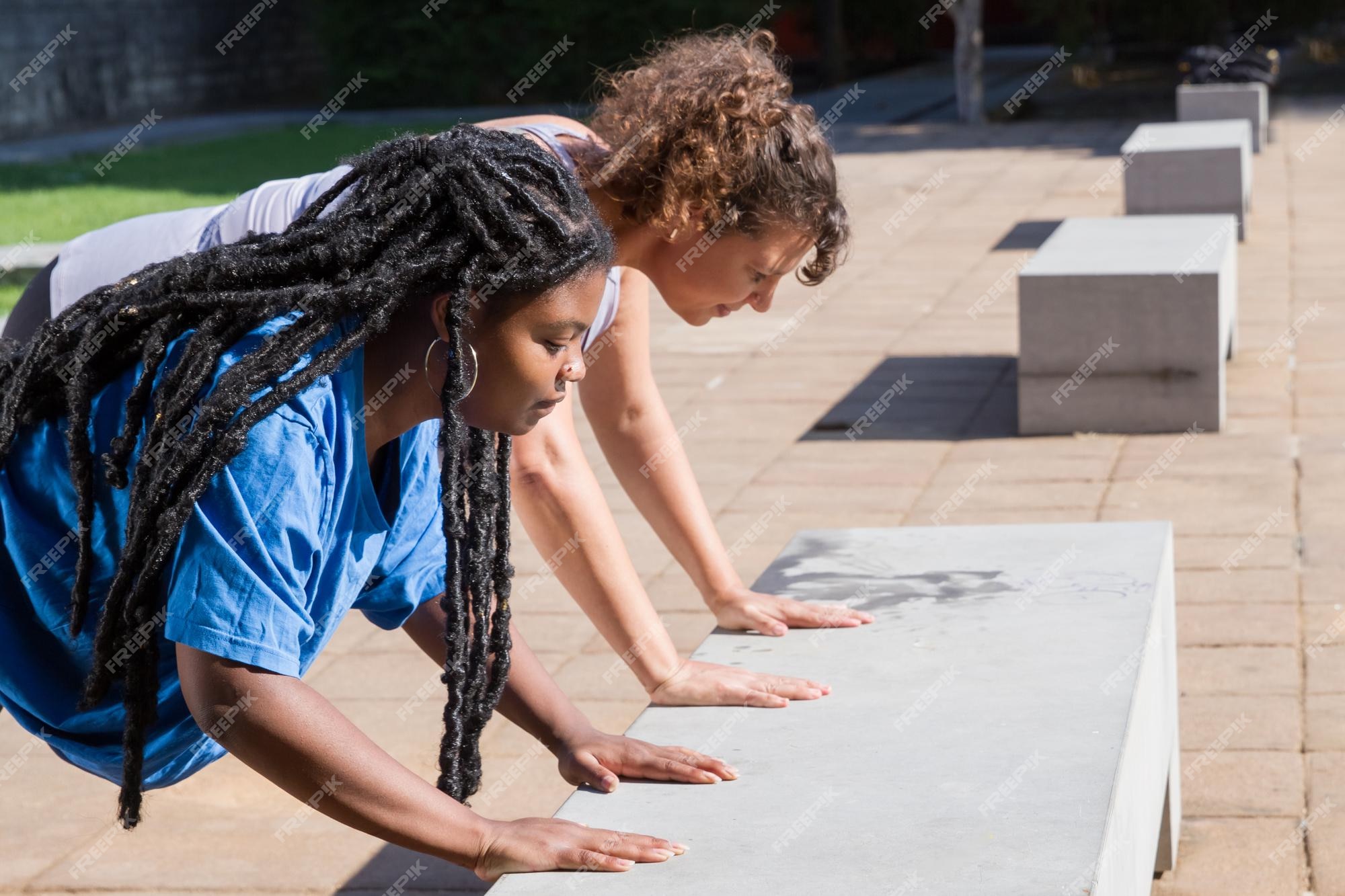 Mujeres de grande concentradas haciendo deporte al aire libre. mujeres gorditas concentradas de diferentes nacionalidades en ropa deportiva haciendo flexiones. deporte, concepto de cuerpo positivo | Foto Gratis