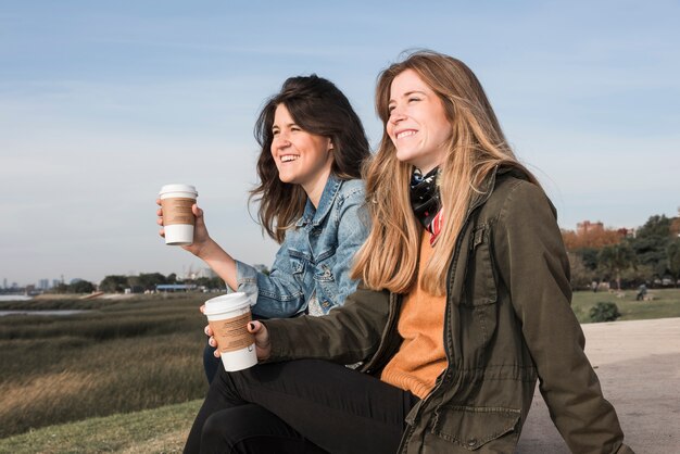 Mujeres con tazas de café sobre fondo de naturaleza