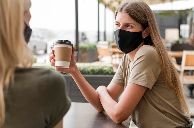 Foto gratuita mujeres en terraza con máscara