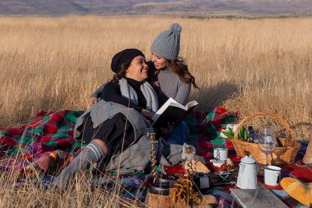 Mujeres de tiro completo acostadas sobre una manta al aire libre