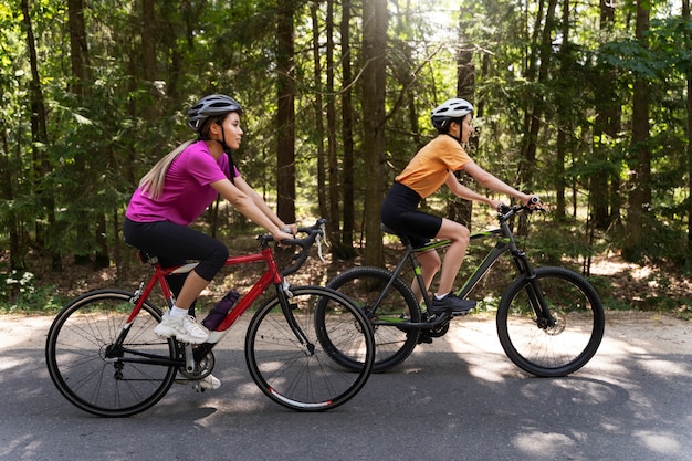 Foto gratuita mujeres de tiro completo en bicicleta juntas