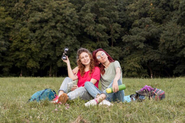 Mujeres de tiro completo con binoculares sonriendo