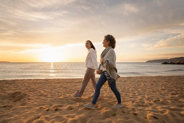 Mujeres de tiro completo caminando en la playa