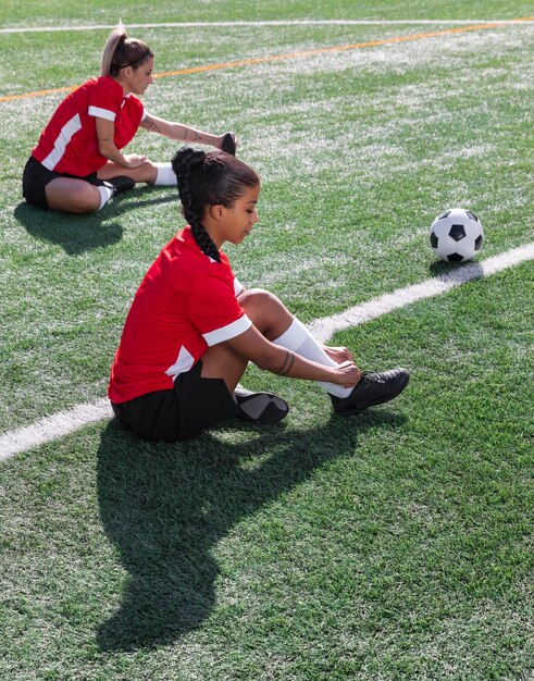 Mujeres de tiro completo en el campo de fútbol