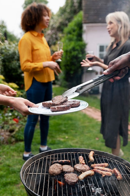 Mujeres de tiro completo charlando cerca de la barbacoa