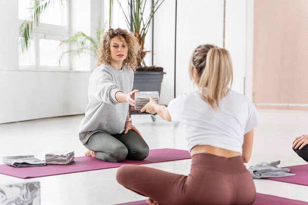 Mujeres de tiro completo en clase de yoga