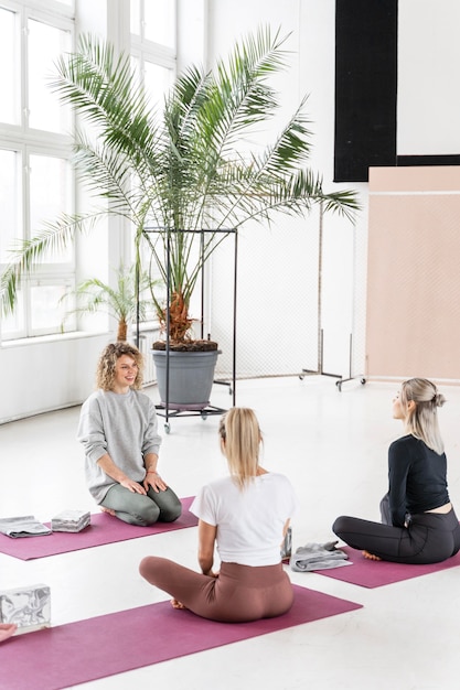 Mujeres de tiro completo en colchonetas de yoga