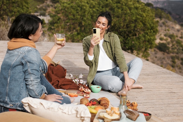 Mujeres de tiro completo con comida deliciosa.