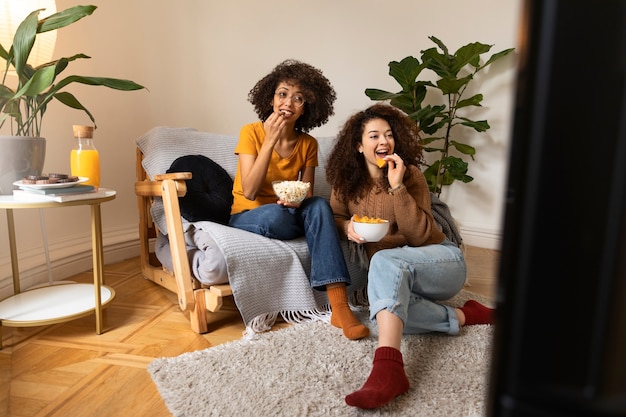 Foto gratuita mujeres de tiro completo comiendo bocadillos