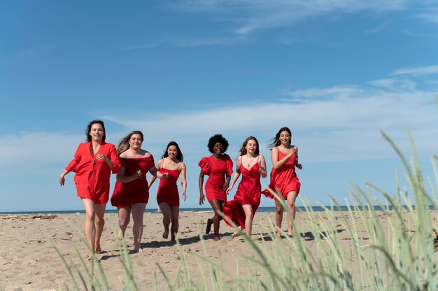 Mujeres de tiro completo corriendo en la playa