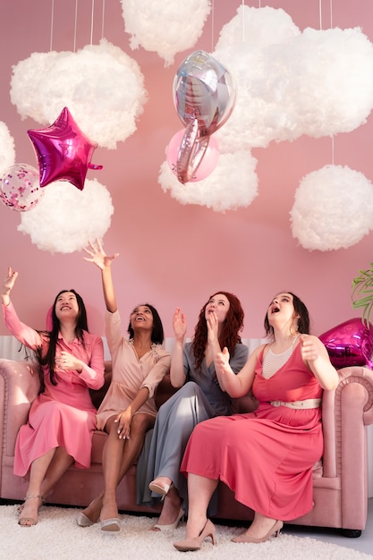 Mujeres de tiro completo divirtiéndose con globos.