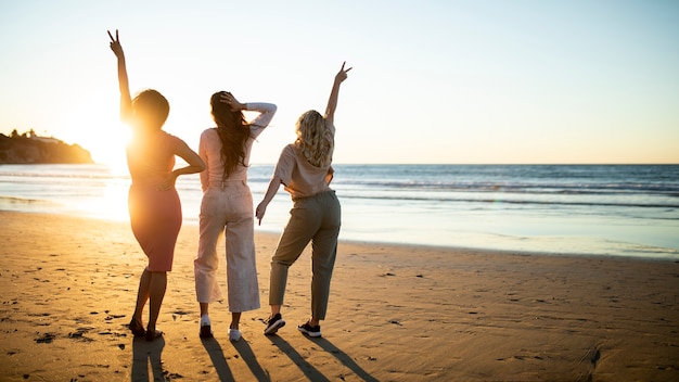 Mujeres de tiro completo divirtiéndose en la playa