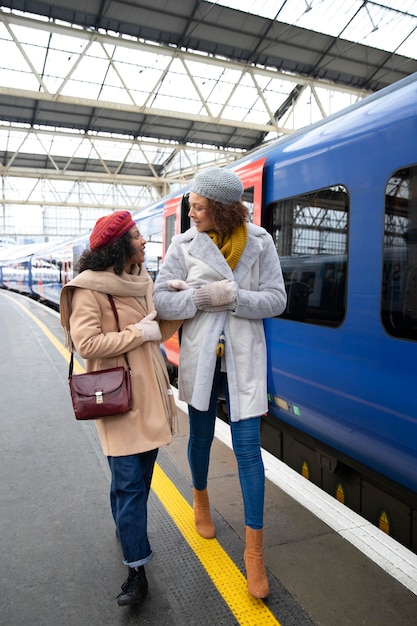 Foto gratuita mujeres de tiro completo en la estación de tren