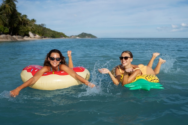 Mujeres de tiro completo en flotadores al aire libre