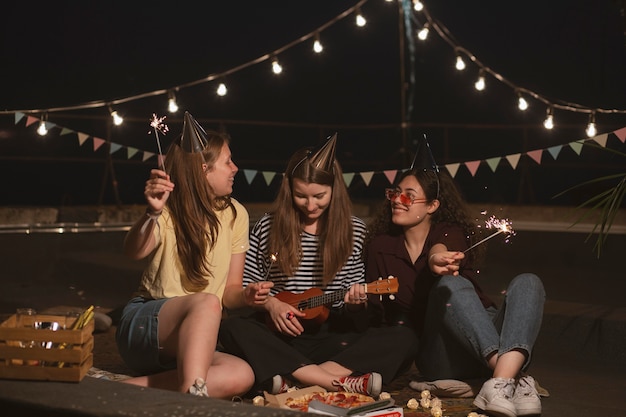 Mujeres de tiro completo con fuegos artificiales