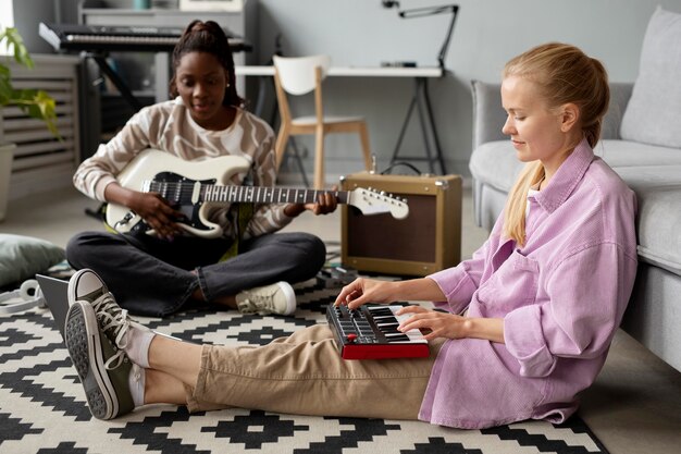 Mujeres de tiro completo con instrumentos en el piso