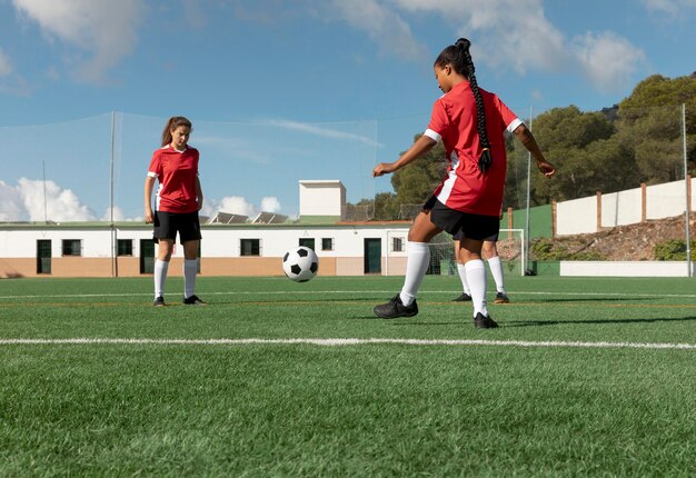 Mujeres de tiro completo jugando al fútbol