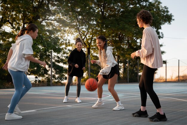 Mujeres de tiro completo jugando baloncesto