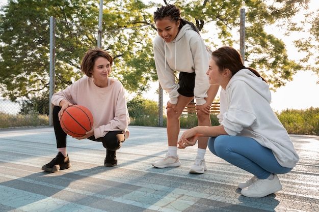 Mujeres de tiro completo jugando baloncesto