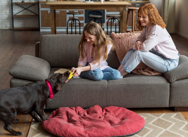 Mujeres de tiro completo jugando con mascota