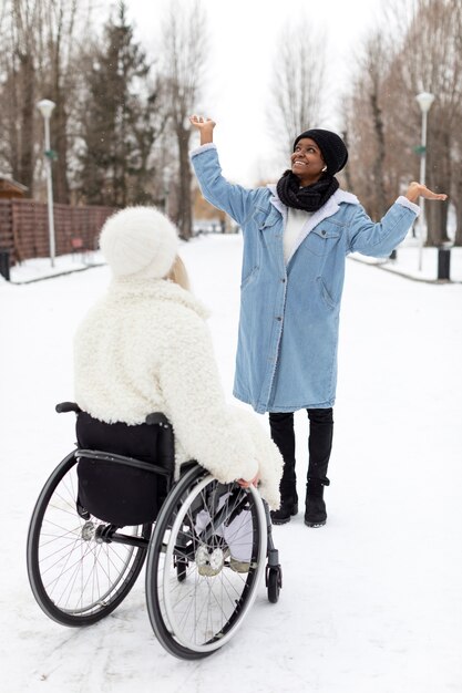 Foto gratuita mujeres de tiro completo jugando con nieve