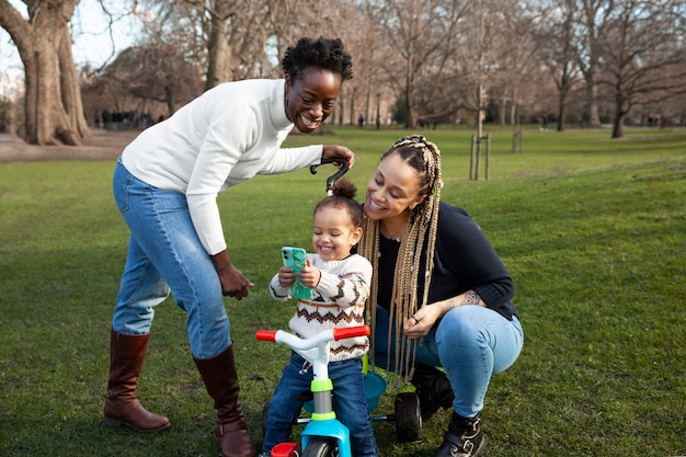 Mujeres de tiro completo y niña feliz en el parque