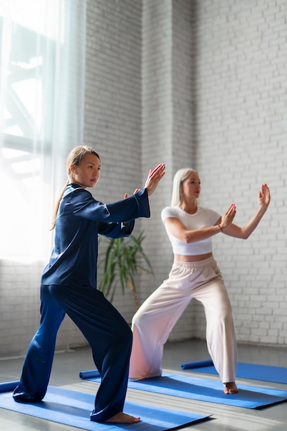 Foto gratuita mujeres de tiro completo practicando tai chi juntas