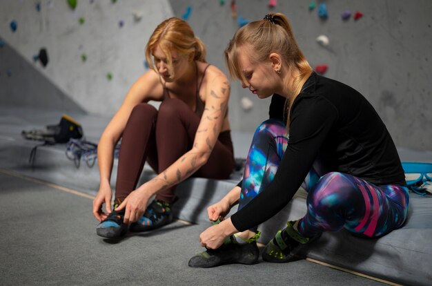 Foto gratuita mujeres de tiro completo preparándose para escalar la pared