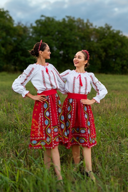 Mujeres de tiro completo con ropa tradicional.