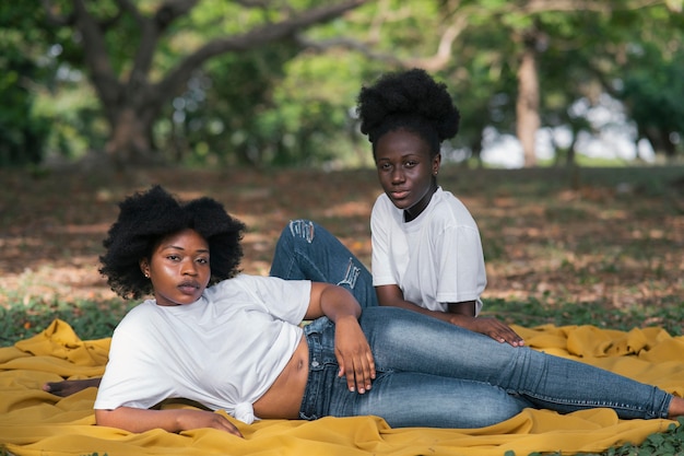 Foto gratuita mujeres de tiro completo sentados al aire libre