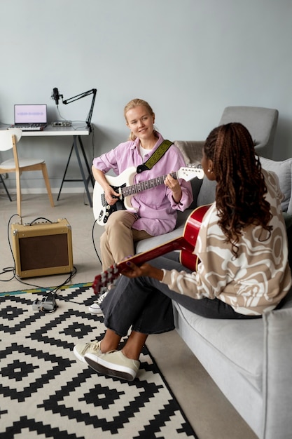 Mujeres de tiro completo tocando la guitarra