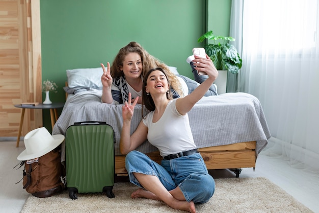 Mujeres de tiro completo tomando selfies juntas