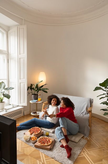 Mujeres de tiro completo viendo la televisión