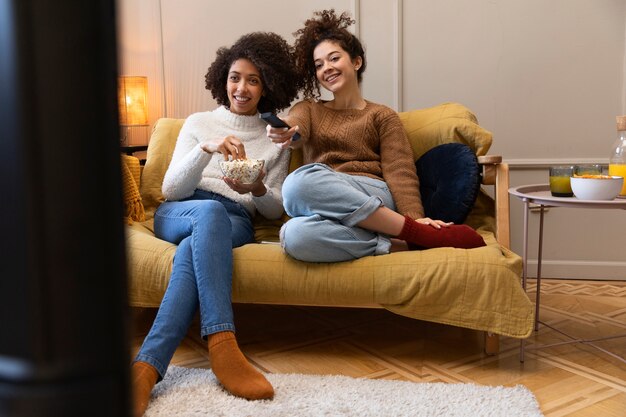 Mujeres de tiro completo viendo la televisión